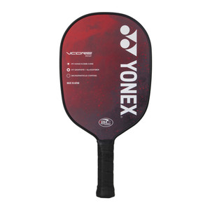 Yonex VCORE Composite Fiberglass and Carbon Fiber Pickleball Paddle features the VCORE model name and paddle materials listed down the left side, and a large YONEX logo down the right side. Red paddle background with white accent and USAP Approved logo.